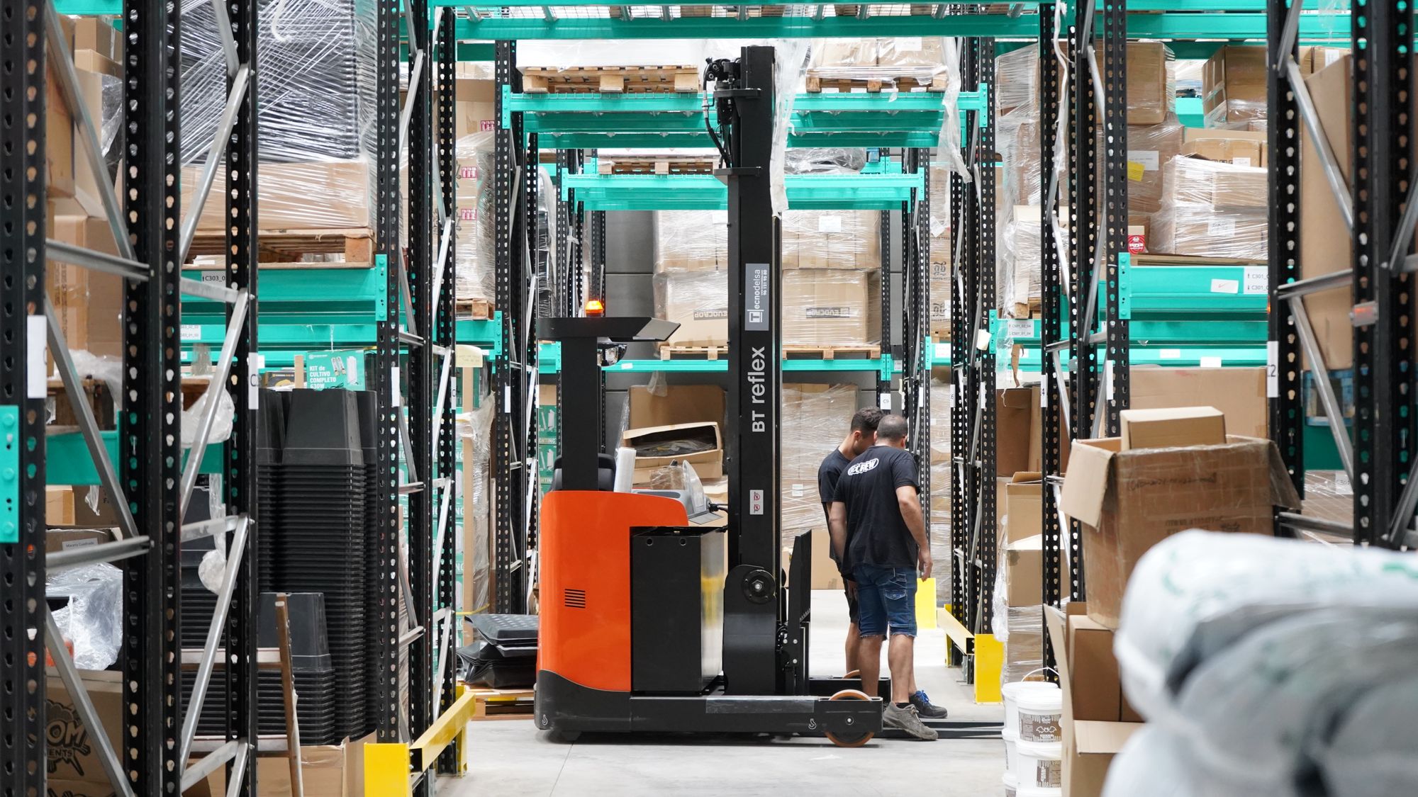 A forklift working the aisles of a finished goods warehouse